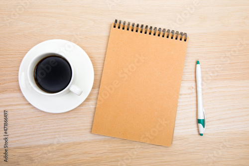 open notepad, cup of coffee, pen  on wooden background spiral notebook on table Business, planning, education, morning life working from home concept Top view Flat lay Mock up- Image