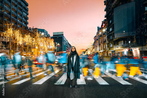 Foto Young woman on zebra crossing in the city at night