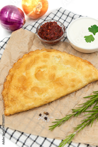 Delicious cheburek with meat and tomato hot sauce. East cuisine meat pastry.