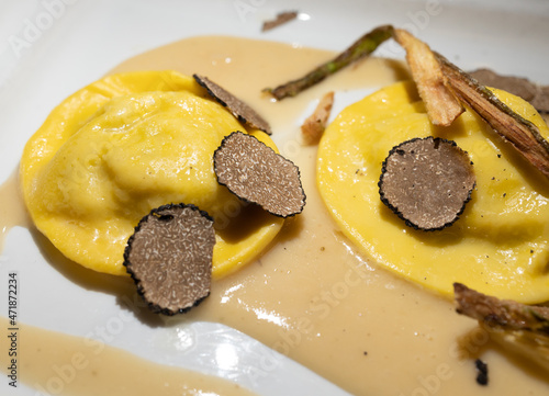 Italian food, fresh home made red potato stuffed pasta tortellacci or ravioli dumplings with summer black truffle and cripsy green asparagus, Parma, Emilia Romagna, Italy photo