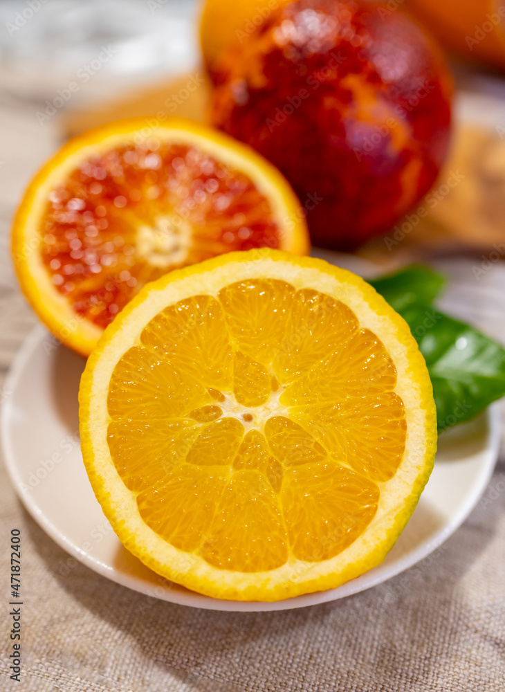 Sicilian sweet juicy yellow and red blood oranges with green leaves close up Sicilian sweet juicy yellow and red blood oranges with green leaves close up