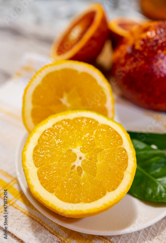 Sicilian sweet juicy yellow and red blood oranges with green leaves close up