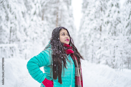  Portrait of a beautiful woman dressed with colourful jacket. A beautiful woman in coloured jacket walking through the Magical winter forest.