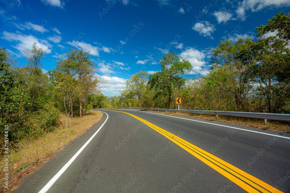 Long road with trees on roadside ,Empty asphalt road and natural landscape under the blue sky Long road with trees on roadside ,Empty asphalt road and natural landscape under the blue sky