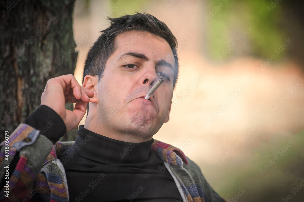 Closeup detail view of man smoke marijuana ganja joint cigarette Closeup detail view of man smoke marijuana ganja joint cigarette
