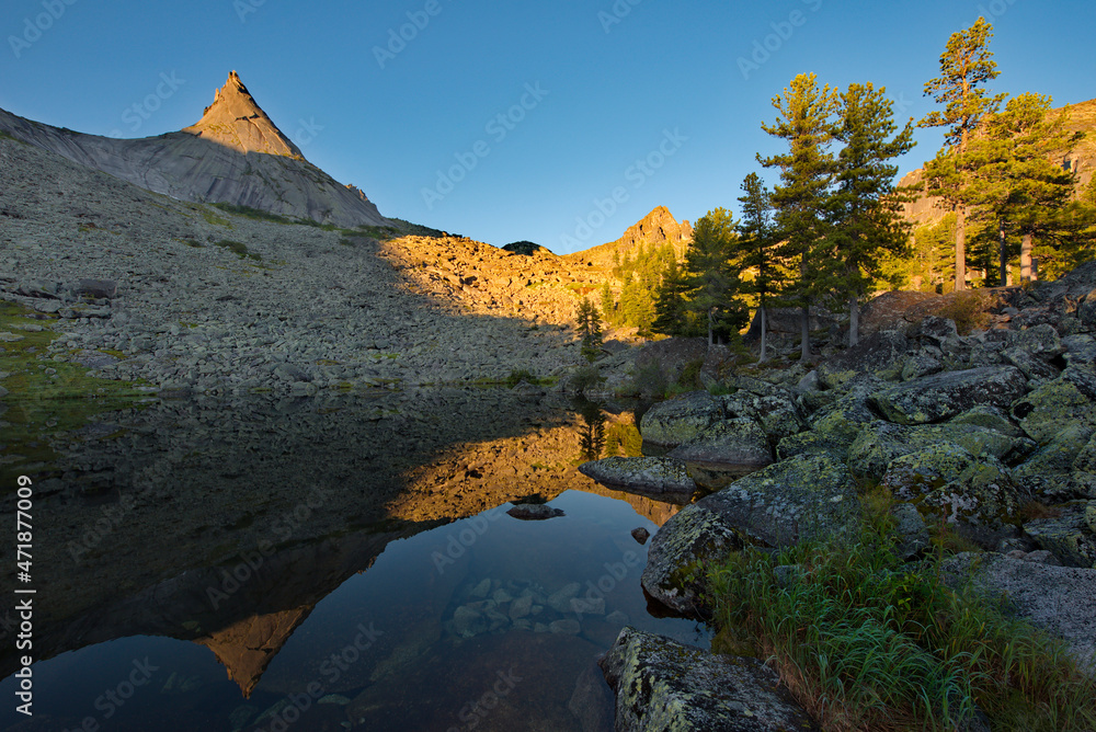 Russia. Krasnoyarsk Territory. Reflections of harsh rocks in the lakes of the Ergaki Natural Mountain Park.