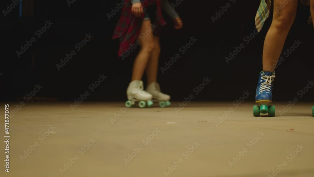 Female legs in roller blades, skating fast at the roller park on floor
