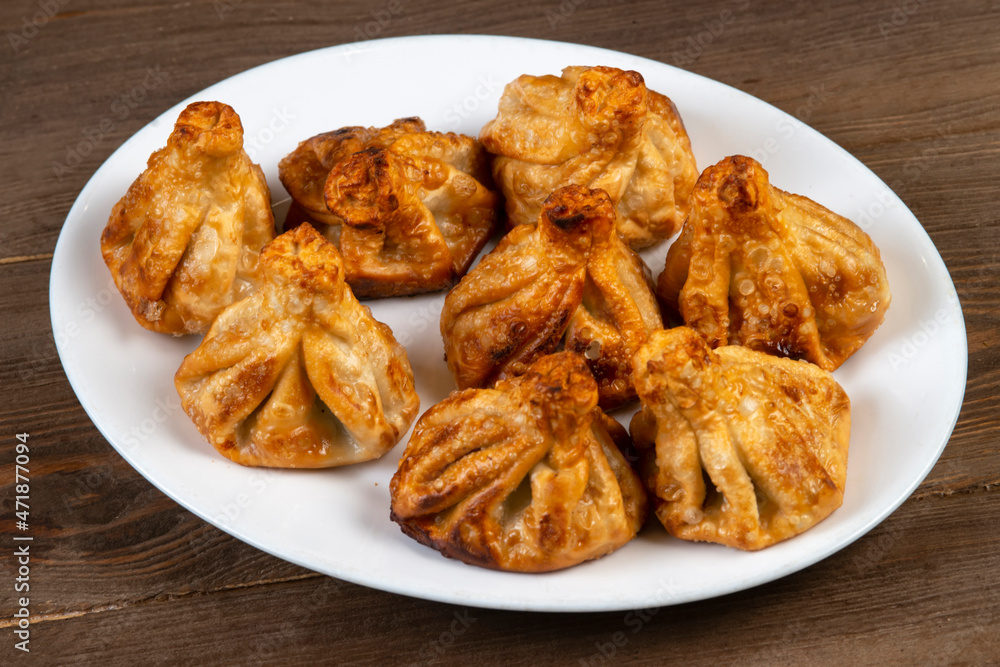 Fried khinkali in a white plate.Georgian cuisine. Fried khinkali in a white plate.Georgian cuisine.