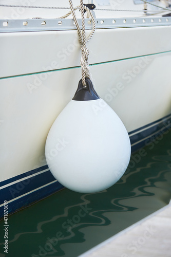 Foto White fenders suspended between a boat and dockside for protection