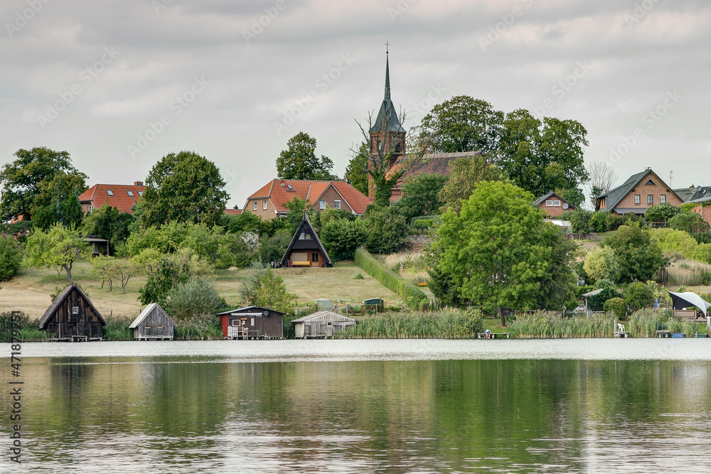 Idyllic on the southwestern shore of lake Plätlinsee lies the small village Wustrow. On the hill above the lake rises since 1896 a brick church. Idyllic on the southwestern shore of lake Plätlinsee lies the small village Wustrow. On the hill above the lake rises since 1896 a brick church.