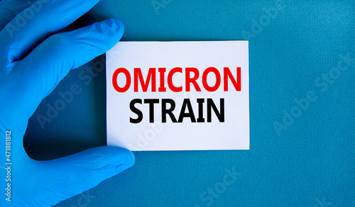New covid-19 omicron variant strain symbol. Hand in blue glove with white card. Concept words Omicron strain. Medical and COVID-19 omicron variant strain concept. Copy space.