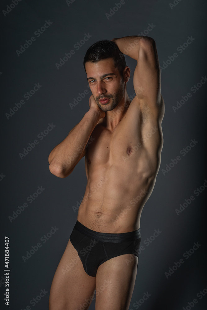 Sensual close-up portrait of a handsome male with bare torso posing in black undeware on isolated background Sensual close-up portrait of a handsome male with bare torso posing in black undeware on isolated background