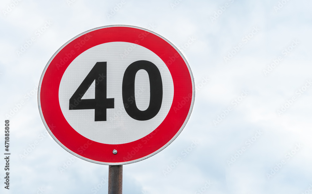 Close-up of a 40 speed limit road sign on a sky background with clouds with copy space