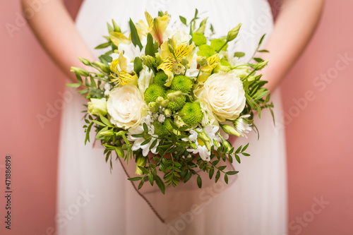 Beautiful wedding bouquet in hands of the bride in detail