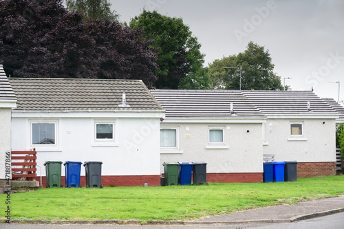 Row of council houses with colour wheelie bins outside