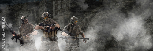Bild auf Leinwand Three mercenary soldiers during a special operation in the smoke against the background of a ruins - photo with copy space