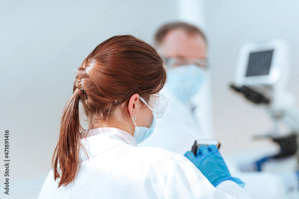 close up. female scientist uses her smartphone in the lab. close up. female scientist uses her smartphone in the lab.