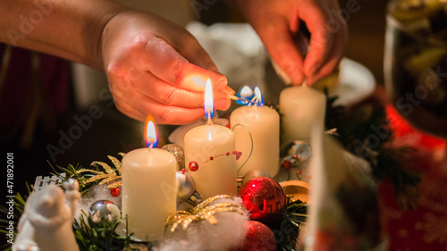 detail of a woman lighting an advent candle