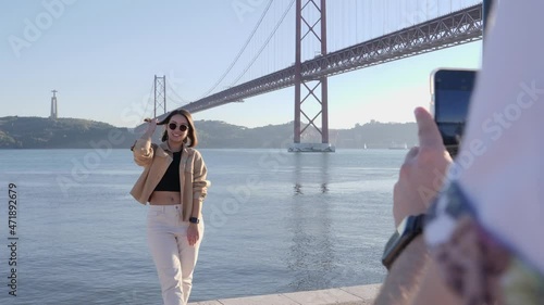 Female tourist posing for photo in front of famous bridge and Cristo Rei statue photo