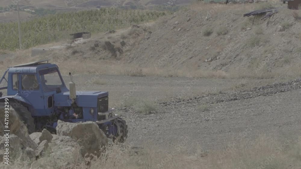 Farm tractors. Tractor in dusty arid soil. Agribusiness. Agriculture and environment. A farmer works on a tractor. Slow Motion 100 fps Farm tractors. Tractor in dusty arid soil. Agribusiness. Agriculture and environment. A farmer works on a tractor. Slow Motion 100 fps