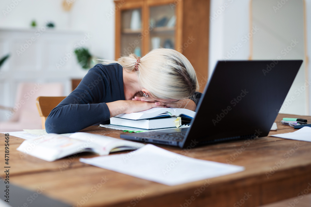 Female student preparing for exams and has her head resting on books. Female student preparing for exams and has her head resting on books.