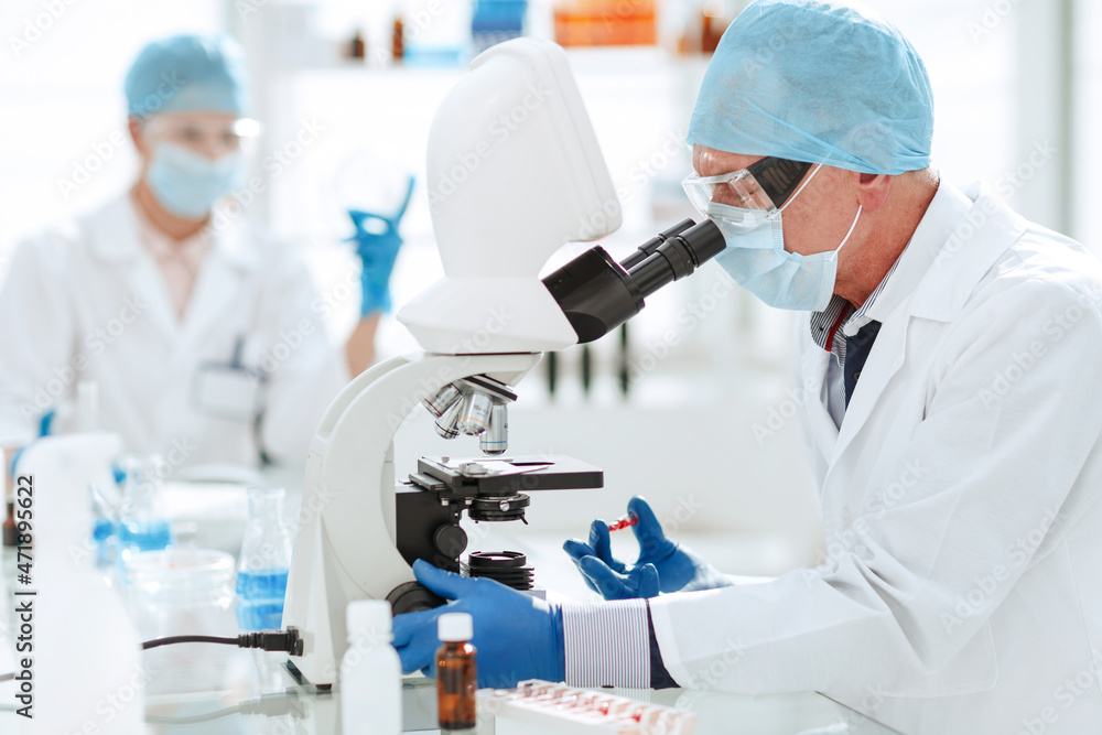 scientist opening an ampoule with a new vaccine . scientist opening an ampoule with a new vaccine .