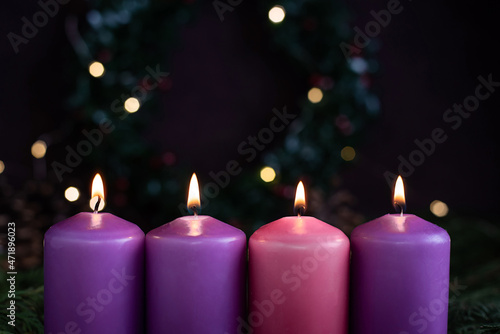 Close-up of four burning purple advent candles.