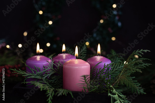 Three purple and one pink advent candles in Christmas eve.