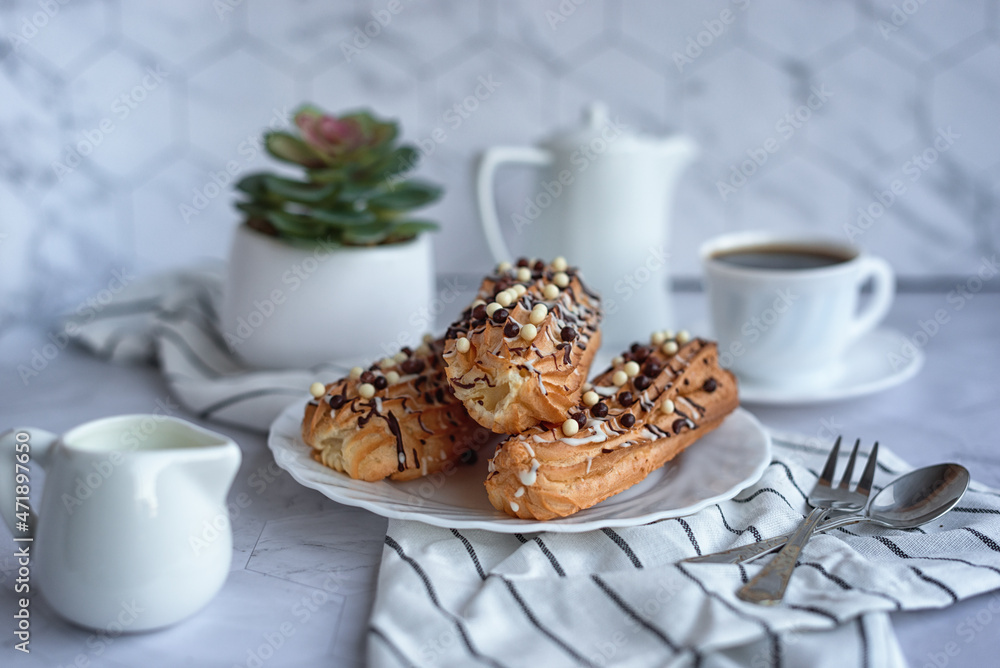 sweet French breakfast: coffee and eclairs on a light grey table
sweet French breakfast: coffee and eclairs on a light grey table