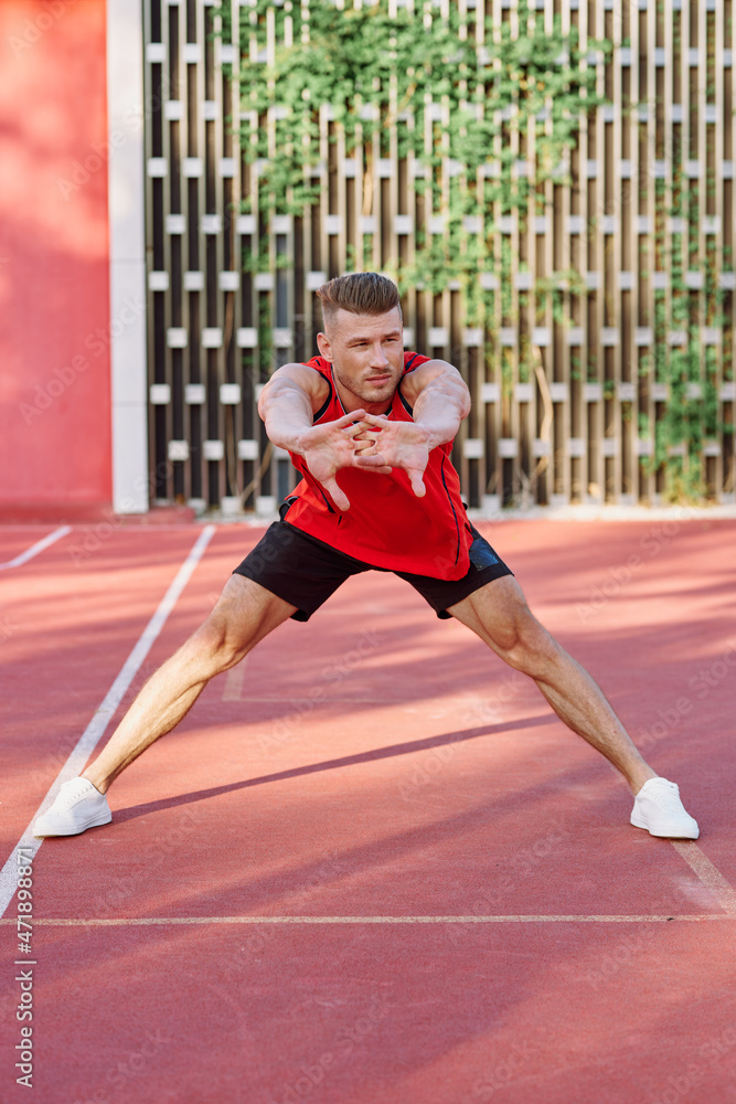 athletic man in red jersey on the sports ground exercise
