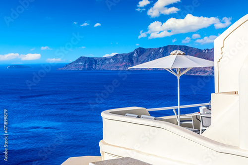 Luxury hotel in Oia, Santorini, Greece. Iconic image of vacation in Greece with sea and umbrella © Nikolay N. Antonov