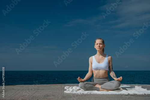 Yoga practice and meditation in nature. Woman practicing near Black sea. © grthirteen