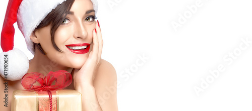 Christmas woman. Gorgeous Miss Santa with a Golden Gift smiling at camera. Panorama banner isolated on white