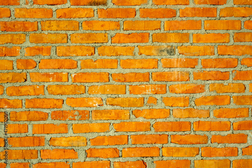 Red brick wall with gray cement glue joint. Creative vintage background.