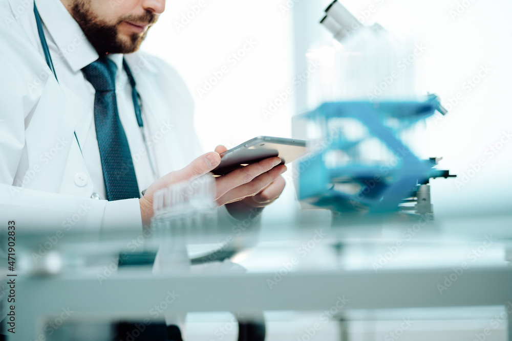 scientist reading his notes in a digital tablet. scientist reading his notes in a digital tablet.