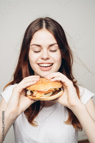 woman with a hamburger in her hands a snack fast food close-up