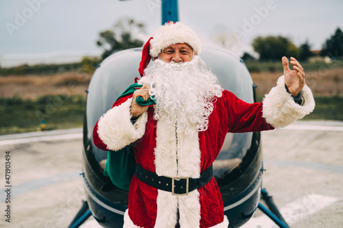 Happy Santa Claus arrives via helicopter to deliver presents to children.