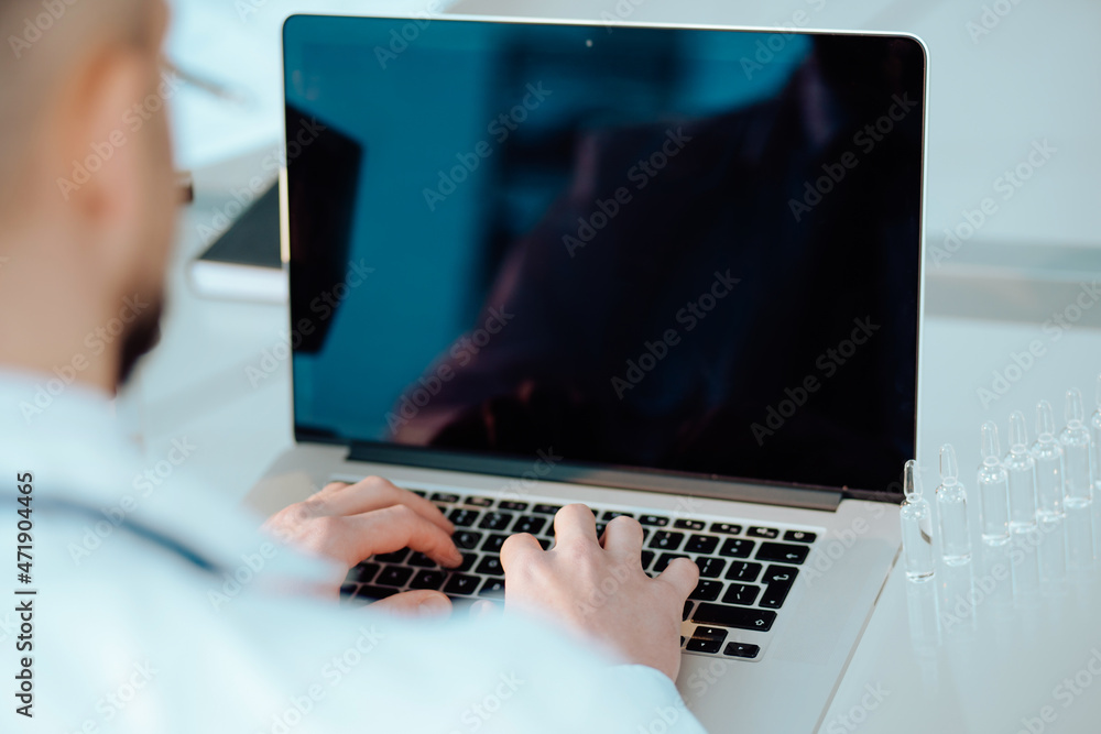 science lab technician using a laptop in the lab.