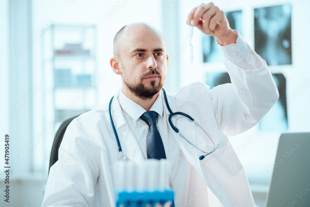 young scientist looks at an ampoule with a vaccine. young scientist looks at an ampoule with a vaccine.