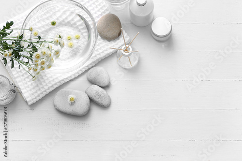 Spa set with bowl of water on light background