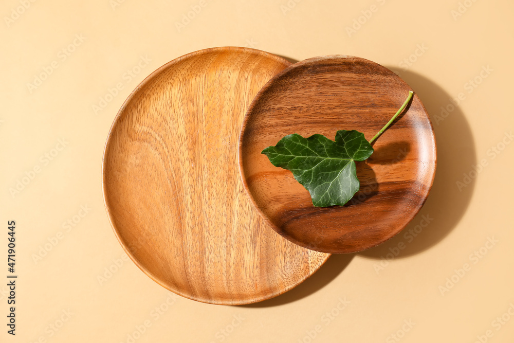 Wooden plates and ivy leaf on color background Wooden plates and ivy leaf on color background
