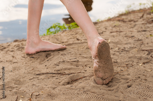 bare children's feet are standing on the sand