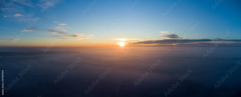 Sunrise over thick autumn fog. Panorama over the clouds in the morning.