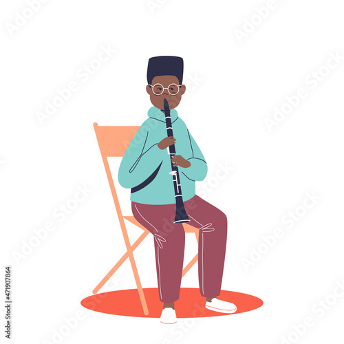 African boy playing flute. Small kid play classical music. Children orchestra and musical education