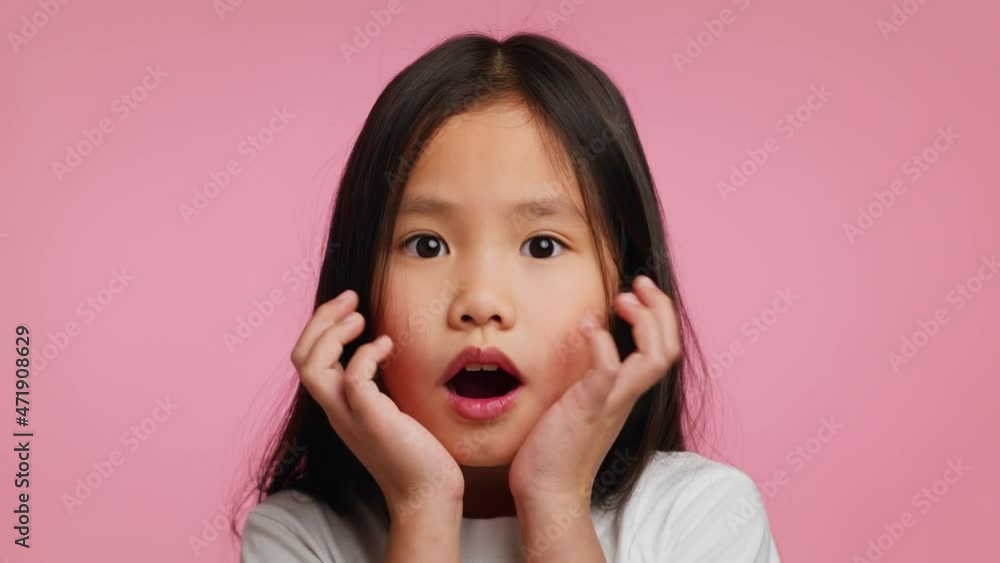 Surprised Korean Little Girl Touching Face In Shock, Pink Background Surprised Korean Little Girl Touching Face In Shock, Pink Background
