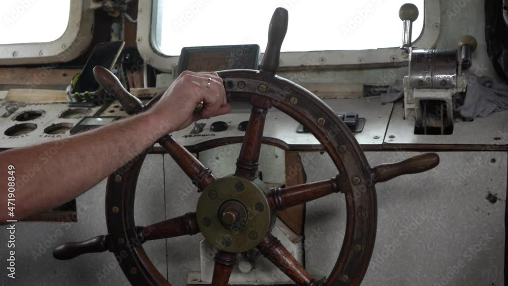 Wooden steering wheel is turned by hand. Steering wheel turns left and