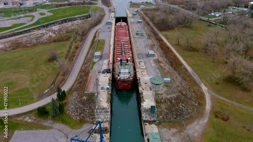 A self discharging bulk carrier ship prepares to cross the locks of the Beauharnois Canal in the St Lawrence Seaway, near Montreal, Quebec. High quality 4K aerial view. photo