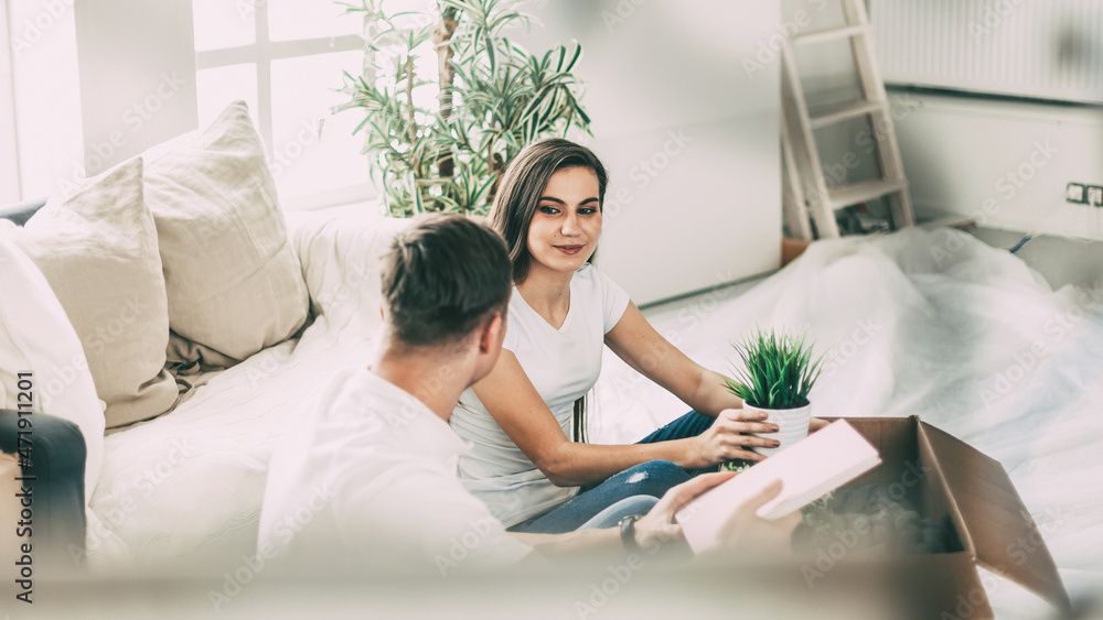 happy couple sitting on the sofa in a new apartment. happy couple sitting on the sofa in a new apartment.