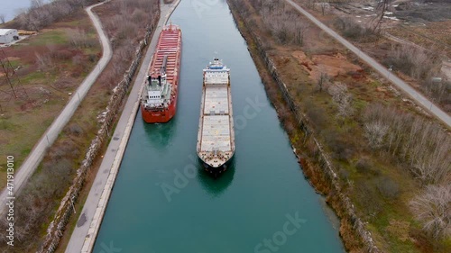 Two cargo ships maneuver inside the Beauharnois Canal in the St Lawrence Seaway, near Montreal, Quebec. High quality 4K aerial view.