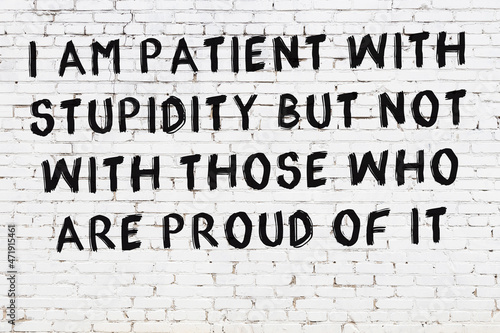 Painted black mindful inscription on white brick wall background